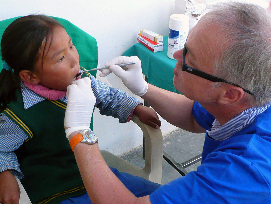 Zahnarzt Dr. Roos bei der Behandlung einer kleinen Patientin.